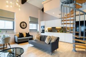 Livestay 3-Bed Loft Apartments in the Heart of Manchester في مانشستر: غرفة معيشة مع أريكة وطاولة