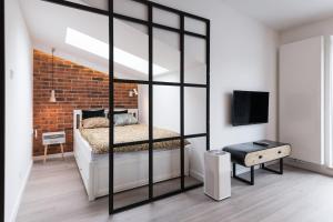 a bedroom with a bed and a brick wall at Apartament Polka Dots in Krakow