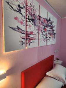 a bedroom with four paintings on the wall at B&B Villa Sabrina in Arezzo