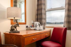 a room with a desk with a lamp and a red chair at The Red Admiral Gosforth CA20 1BP in Seascale