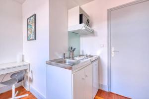 圣康坦Appartement 5的带水槽和微波炉的白色厨房