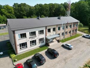 een uitzicht boven een gebouw met auto's op een parkeerplaats bij Hostelis R27 in Aizpute