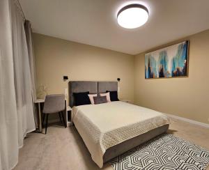 ein Schlafzimmer mit einem Bett und einem Tisch mit einem Stuhl in der Unterkunft ANTRI Namai - Apartamentai Birštone in Birštonas