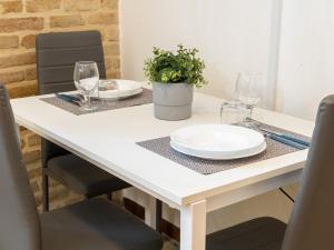 un tavolo bianco con occhiali e una pianta sopra di Maison all'Arco a Corridonia