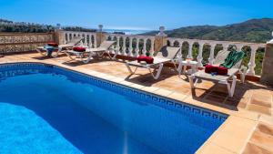 - une piscine avec des chaises longues et des chaises à côté d'un balcon dans l'établissement Casa Amparo Casitas Select, à Frigiliana