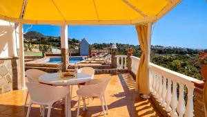 d'un balcon avec une table, des chaises et une piscine. dans l'établissement Casa Amparo Casitas Select, à Frigiliana