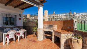 une terrasse avec une cheminée en pierre et des chaises dans l'établissement Casa Amparo Casitas Select, à Frigiliana