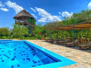 a swimming pool in front of a gazebo at Murchison Falls Bamboo Village in Murchison Falls National Park