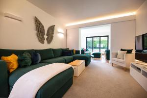 uma sala de estar com um sofá verde num quarto em Lyndhurst House em Canterbury