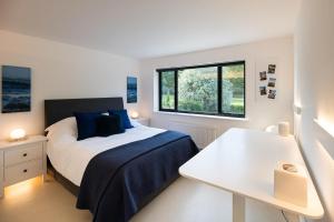 um quarto branco com uma cama e uma janela em Lyndhurst House em Canterbury