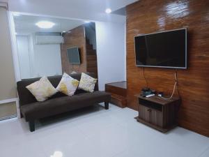 a living room with a couch and a flat screen tv at 2 Bedrooms Units Forbes Area 5th Avenue BGC Center in Manila