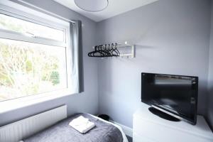 una camera da letto con una grande finestra e una televisione di Honest Hospital House 1 a Southampton