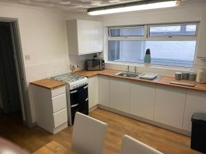 a kitchen with a stove and a sink and a window at Brays View in Ely