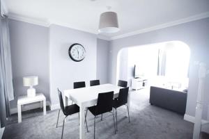 a white dining room with a white table and chairs at Honest Hospital House 1 in Southampton