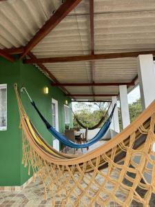 duas redes de descanso num quarto com uma parede verde em Casa Amanhecer do Sol em Alto Paraíso de Goiás