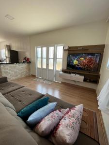 uma sala de estar com um sofá e uma televisão de ecrã plano em Casa Amanhecer do Sol em Alto Paraíso de Goiás