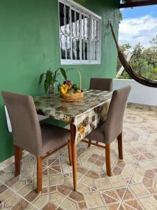 uma mesa de jantar com uma cesta de frutas em Casa Amanhecer do Sol em Alto Paraíso de Goiás