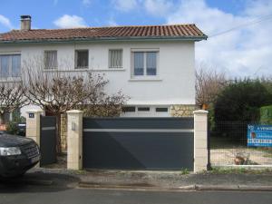 een huis met een blauwe poort ervoor bij Helen's Home in Bergerac