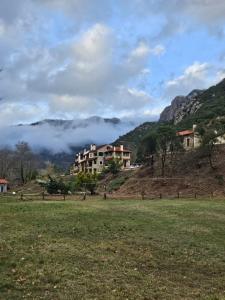 una casa in cima a una collina con un campo di Muntenia Inn Apartments and Suites a Kalavrita