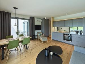 una cucina e un soggiorno con tavolo e sedie di Hideaway an der Weinstraße - Pool & Sauna - Apartments AnDerLage a Spielfeld