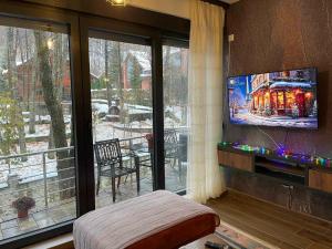 uma sala de estar com televisão e uma grande janela em Lonvilla’s Brezovicë em Štrpce