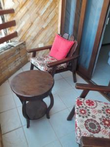 a room with a chair and a table and a stool at Sonia Flats Pipa's Bay - Flat 211 in Pipa