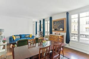sala de estar con mesa y sofá azul en Gros Caillou - Surcouf 2bdr, en París