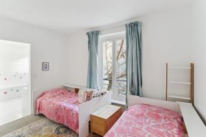 1 dormitorio con 2 camas y ventana en Gros Caillou - Surcouf 2bdr, en París