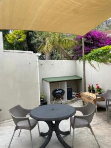 - une table et des chaises sous un parasol sur la terrasse dans l'établissement Bing Heights Suite, à Hermanus