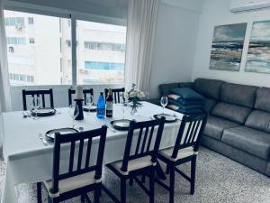 a dining room table with chairs and a couch at SOLMAR Playa Gandia SOLO FAMILIAS in Playa de Gandia