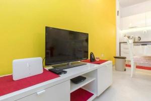 ein Wohnzimmer mit einem großen TV und einem Laptop in der Unterkunft Apartment Burica in Primošten