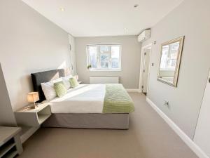 Un dormitorio con una cama grande y una ventana en 3-Bedroom Flat with FREE parking in the Heart of Hampton Hill Village en Hampton Hill