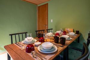 a wooden table with plates and wine glasses on it at Satorie Beppu in Beppu