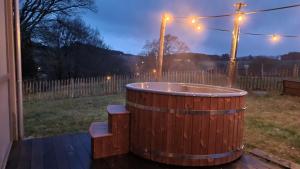 uma banheira de hidromassagem de madeira num quintal à noite em Ardennature vakantiehuizen met privé-sauna em La-Roche-en-Ardenne