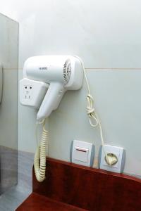 a white hair dryer hanging on a wall at Dereva Hotel Rwamagana in Rwamagana