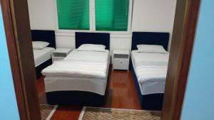 Zimmer mit 2 Betten und 2 Fenstern in der Unterkunft Apartments Amina Sarajevo in Sarajevo