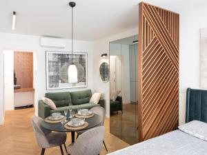 Una sala de estar con un sofá verde y una mesa. en JU3 Apartments, en Liubliana