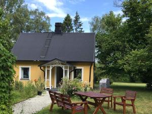 uma casa amarela com uma mesa de piquenique em frente em Holiday home KLINTEHAMN IV em Klintehamn