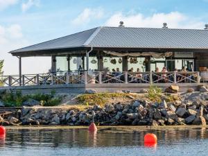 a large building with people sitting on a deck next to the water at Holiday home Gnarp II in Jättendal