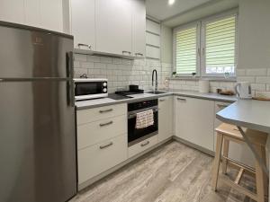 a kitchen with white cabinets and a stainless steel refrigerator at Good Days Apartment in Warsaw