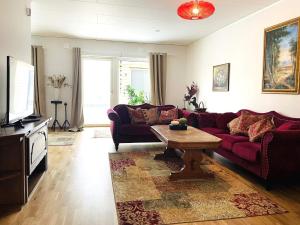 uma sala de estar com um sofá vermelho e uma mesa de centro em Holiday home Öjersjö em Öjersjö