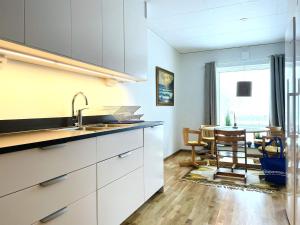uma cozinha com um lavatório e uma mesa com cadeiras em Holiday home Öjersjö em Öjersjö