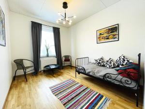 um quarto com uma cama e cadeiras e uma janela em Holiday home Öjersjö em Öjersjö