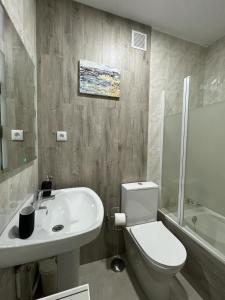 a bathroom with a white sink and a toilet at SOLMAR Playa Gandia SOLO FAMILIAS in Playa de Gandia