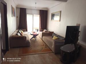een woonkamer met een bank en een tafel bij شقة في اقامة in Essaouira