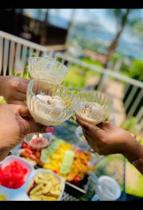 een groep mensen die een glas eten omhoog houden bij Palm View Guest House in Pretoria