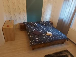 a bedroom with a bed with a blue comforter with stars at casa hermina in Buşteni