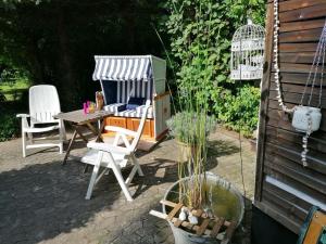 eine Terrasse mit einem Tisch, Stühlen und einem Pavillon in der Unterkunft Ferienhaus Landliebe in Eschwege