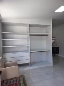 ein Wohnzimmer mit weißen Regalen und einem Sofa in der Unterkunft Linda edícula a 80 m da Praia de Itapuã in Salvador