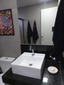 ein Badezimmer mit einem weißen Waschbecken und einer Toilette in der Unterkunft Linda edícula a 80 m da Praia de Itapuã in Salvador